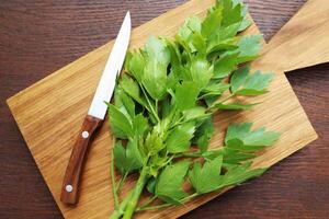 Fresh green leaves of lovage or Levisticum officinale on a wooden cutting board photo