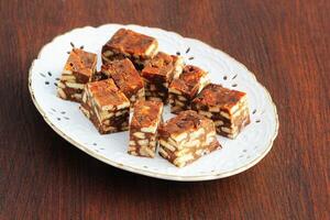 Lazy cake or mosaic cake . Homemade no bake chocolate biscuit cake on a wooden table photo