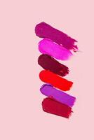 Various lipstick swatch stroke isolated on beige photo