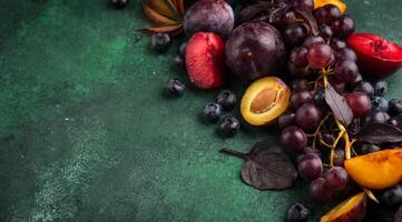 Assortment of purple fruit plum, grape, blueberry and basil photo