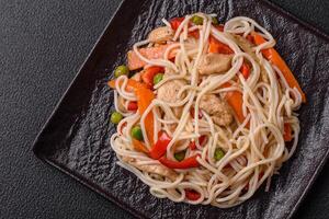 delicioso arroz tallarines o udon con pollo, zanahorias, pimienta, sal, especias y hierbas foto