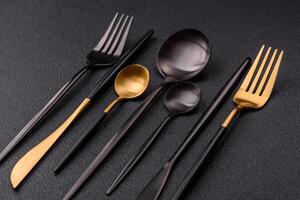 Cutlery fork, knife and spoon on a dark textured concrete background photo