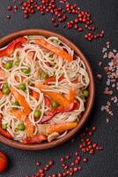 Delicious rice noodles or udon with chicken, carrots, pepper, salt, spices and herbs photo