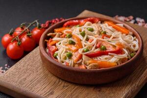 Delicious rice noodles or udon with chicken, carrots, pepper, salt, spices and herbs photo