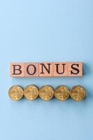 The inscription Bonus made of wooden cubes on a plain background photo