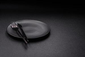 Cutlery fork, knife and spoon on a dark textured concrete background photo