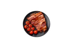 Delicious smoked or grilled ribs with olives, spices and herbs photo