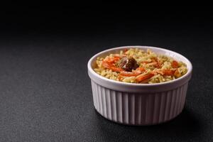 Delicious pilaf with vegetables, salt, spices and herbs in a ceramic plate photo