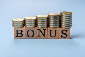 The inscription Bonus made of wooden cubes on a plain background photo