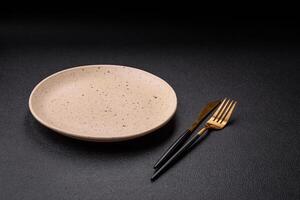 Cutlery fork, knife and spoon on a dark textured concrete background photo