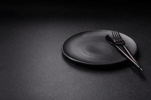 Cutlery fork, knife and spoon on a dark textured concrete background photo