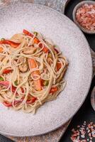 Delicious rice noodles or udon with chicken, carrots, pepper, salt, spices and herbs photo