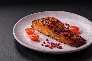 Delicious red salmon fish grilled with sauce and sesame, spices and herbs photo