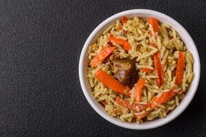 Delicious pilaf with vegetables, salt, spices and herbs in a ceramic plate photo