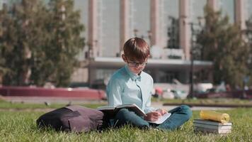 en línea educación, espalda a escuela, contento colegial, aprender lecciones colegial haciendo deberes utilizando un cuaderno y un libro video