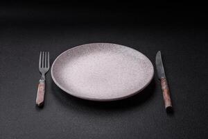 Cutlery fork, knife and spoon on a dark textured concrete background photo