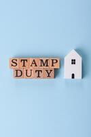 The inscription Stamp Duty made of wooden cubes on a plain background photo