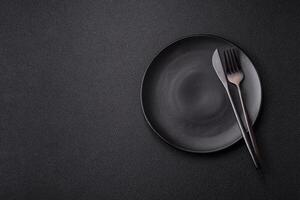 Cutlery fork, knife and spoon on a dark textured concrete background photo