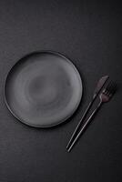 Cutlery fork, knife and spoon on a dark textured concrete background photo