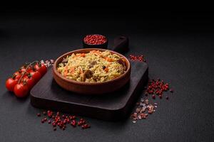 Delicious pilaf with vegetables, salt, spices and herbs in a ceramic plate photo