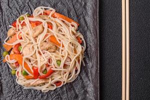 delicioso arroz tallarines o udon con pollo, zanahorias, pimienta, sal, especias y hierbas foto