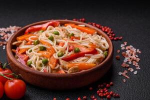 Delicious rice noodles or udon with chicken, carrots, pepper, salt, spices and herbs photo