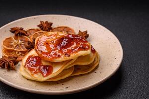 Fresh baked pancakes with delicious jam on a ceramic plate photo