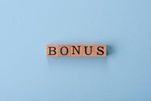 The inscription Bonus made of wooden cubes on a plain background photo