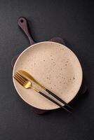 Cutlery fork, knife and spoon on a dark textured concrete background photo