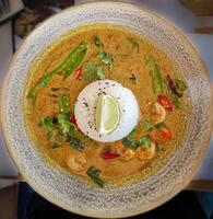 Shrimps in spicy curry sauce and rice on a plate. View from above photo