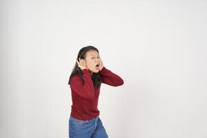 joven asiático mujer en rojo camiseta mano en oreja, hipocresía oír usted concepto aislado en blanco antecedentes foto