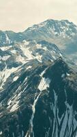 Antenne über dem Tal mit schneebedeckten Bergen in der Ferne video