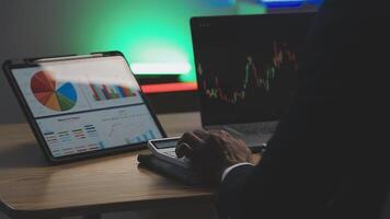 Businessman analyzing a graphic of a stock exchange chart. Back of the head of a young male businessman looking at a stock diagram on the big screen of the computer video