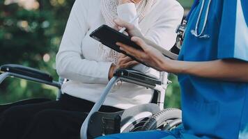 Midsection of female nurse checking blood pressure of woman sitting on wheelchair in clinic video