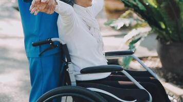 Midsection of female nurse checking blood pressure of woman sitting on wheelchair in clinic video