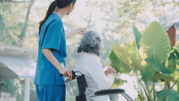 Midsection of female nurse checking blood pressure of woman sitting on wheelchair in clinic video