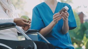 Midsection of female nurse checking blood pressure of woman sitting on wheelchair in clinic video