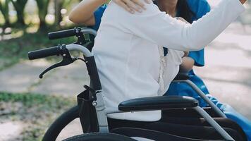 Midsection of female nurse checking blood pressure of woman sitting on wheelchair in clinic video