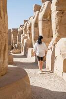 mujer viajero explora el restos de el antiguo karnak templo en el ciudad de luxor en Egipto. foto