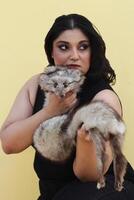 a woman holding a small furry animal in her arms photo