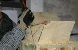 Belluno Italy - 11 02 2023 Close-up of the hand of a skilled craftsman holding a chisel as he firmly drives it into a piece of wood photo