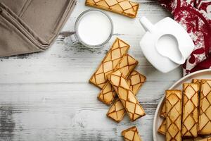 Glazed puff pastry Sfogliatine Glassate and cup of milk on white background, top view photo