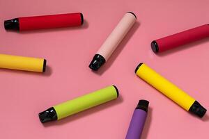 Layout of colorful disposable vapor stick on a light background. Concept of modern e-smoking, vaping and nicotine, electronic cigarettes. photo