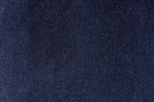 The texture and textile background of a football shirt jersey is made of a dark blue sports clothing fabric. photo