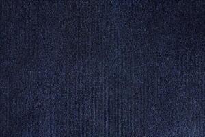 The texture and textile background of a football shirt jersey is made of a dark blue sports clothing fabric. photo