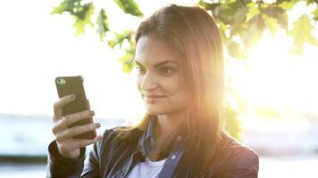 ung skön caucasian kvinna använder sig av smart telefon i de stad video