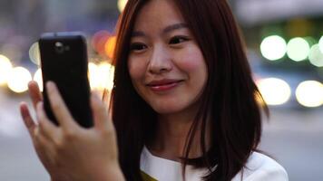 Jeune asiatique femme en utilisant intelligent téléphone dispositif dans le ville des rues video