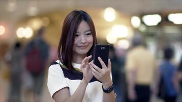 giovane asiatico donna utilizzando inteligente Telefono dispositivo nel il città strade video