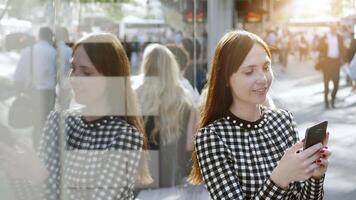 ciudad estilo de vida retrato de atractivo confidente mujer mirando en inteligente teléfono video