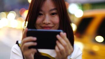 jong Aziatisch vrouw gebruik makend van slim telefoon apparaat in de stad straten video